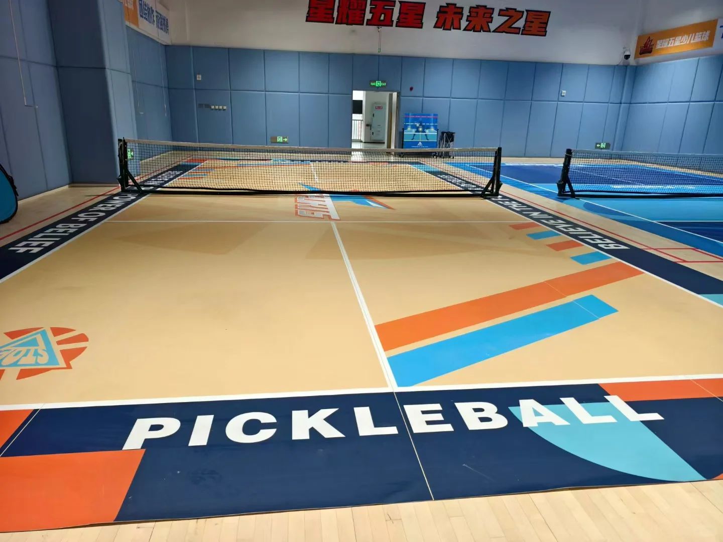 Крытый корт с графическим покрытием и надписью PICKLEBALL